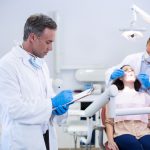 Dentist writing on clipboard