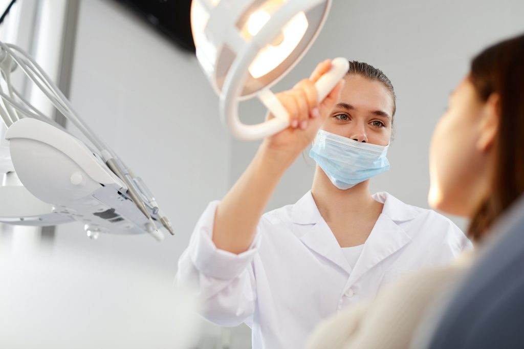 Dentista ajustando la lámpara del sillón dental