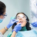 Two dentists working with patient