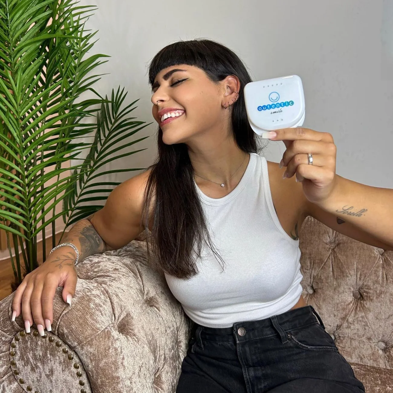 Chica joven morena sonriente sujetando el estuche de Autentic Smile